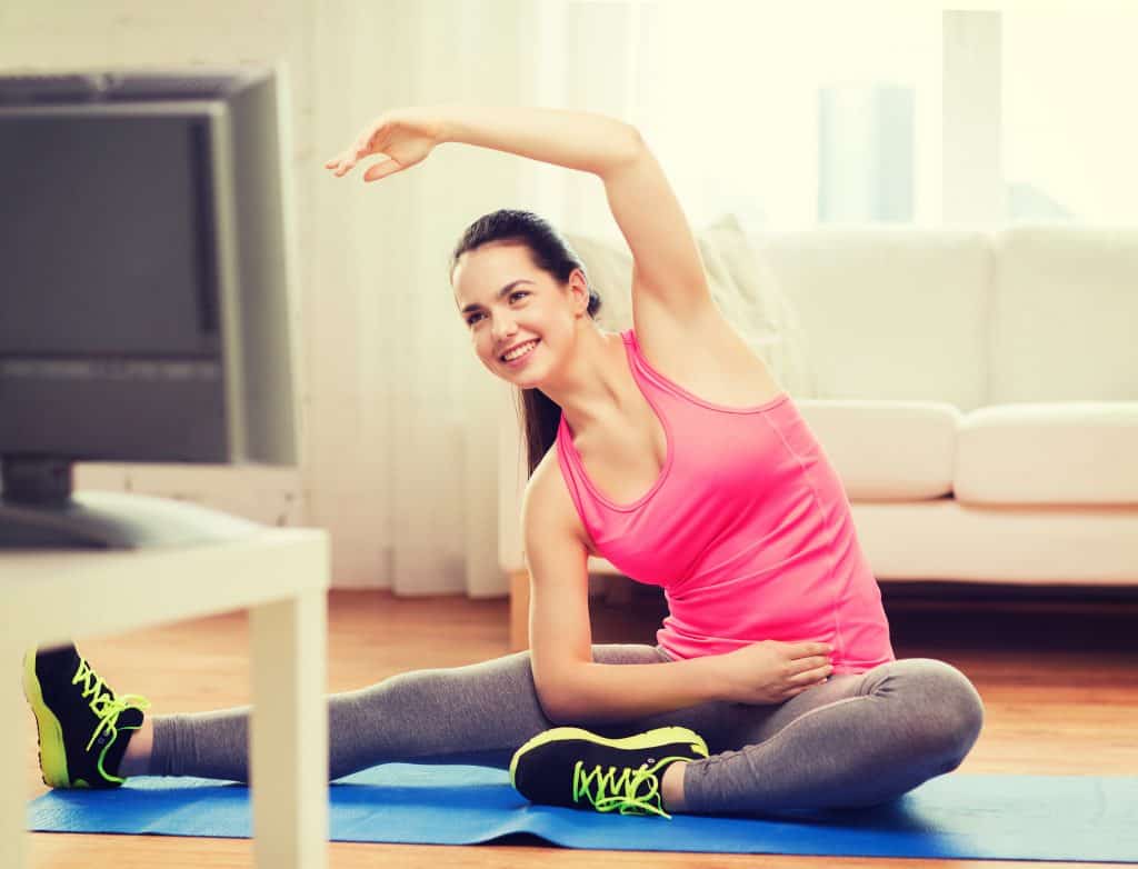 Woman stretching on a yoga mat. Fitness is one of the 5 ways to lower high blood pressure.