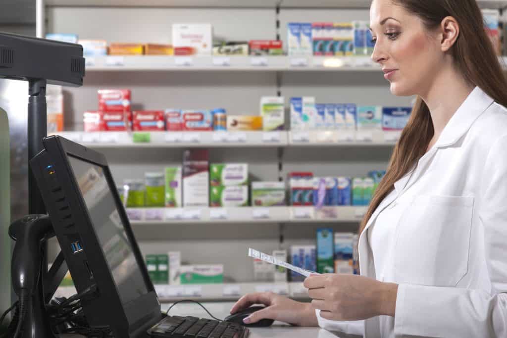 a pharmacists enters a prescription. Dealing with prescriptions requires knowing how to lower your medication costs.