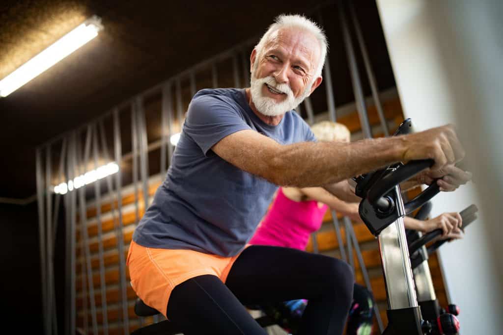 Senior citizen works out on stationary bike. After learning how to treat diabetes, a person may exercise more often.