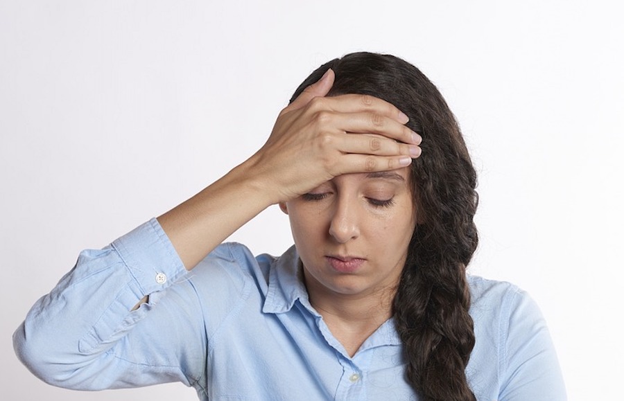 woman suffering with a headache. Headaches are one of the symnptoms of tick-borne diseases