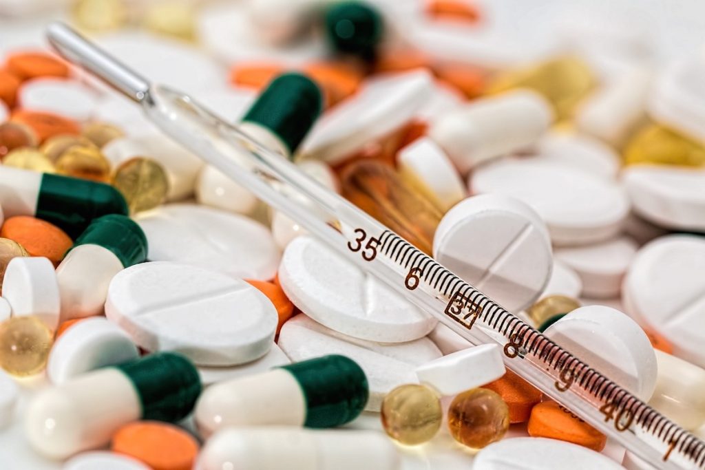 Image shows a collection of pills and a thermometer which outlines the choices a healthcare professional can help you make