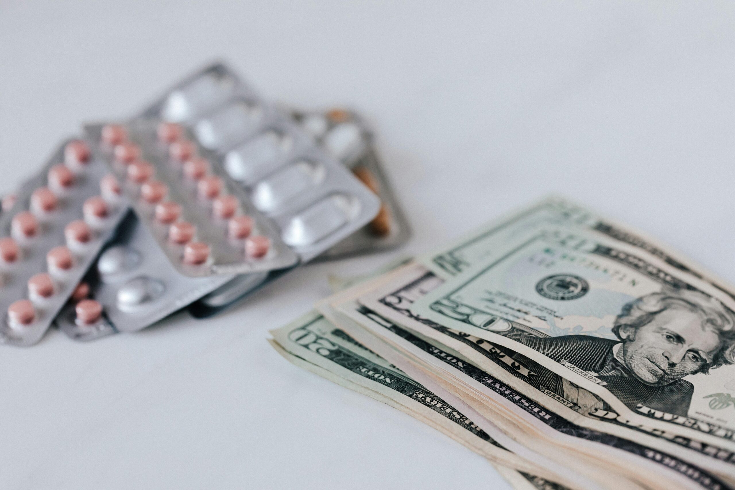 a pack of pills and money representing prescription drug prices increase many Americans face.