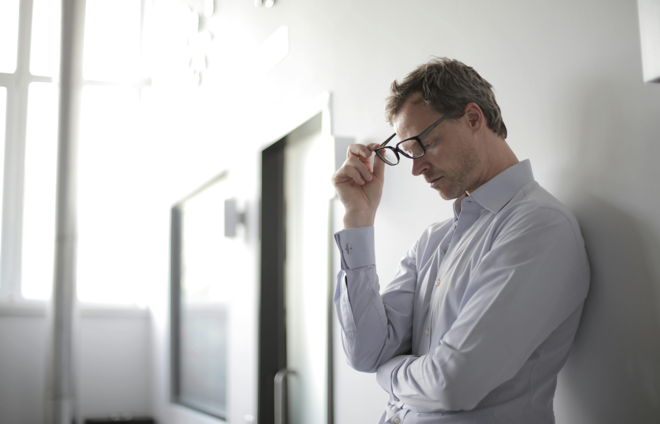 A man looks stressed, holding his glasses, representing mental health and diabetes