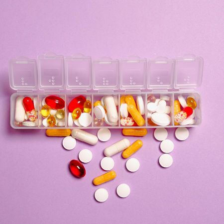 A pill organizer with pills near it, representing medication tracking tips