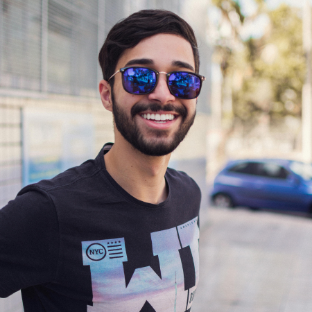 a man with sunglasses smiles, representing how some people feel after taking Abilify for mood disorders