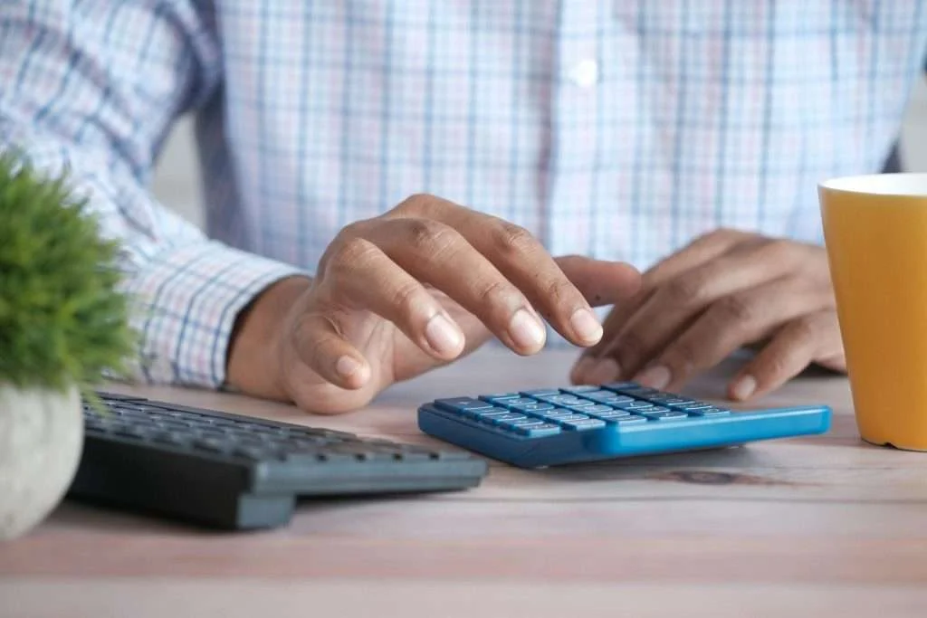 Person using a calculator to budget monthly Eliquis costs with Prescription Hope