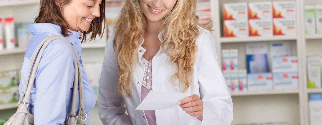 21174263 - young pharmacist and female customer reading prescription paper at pharmacy counter