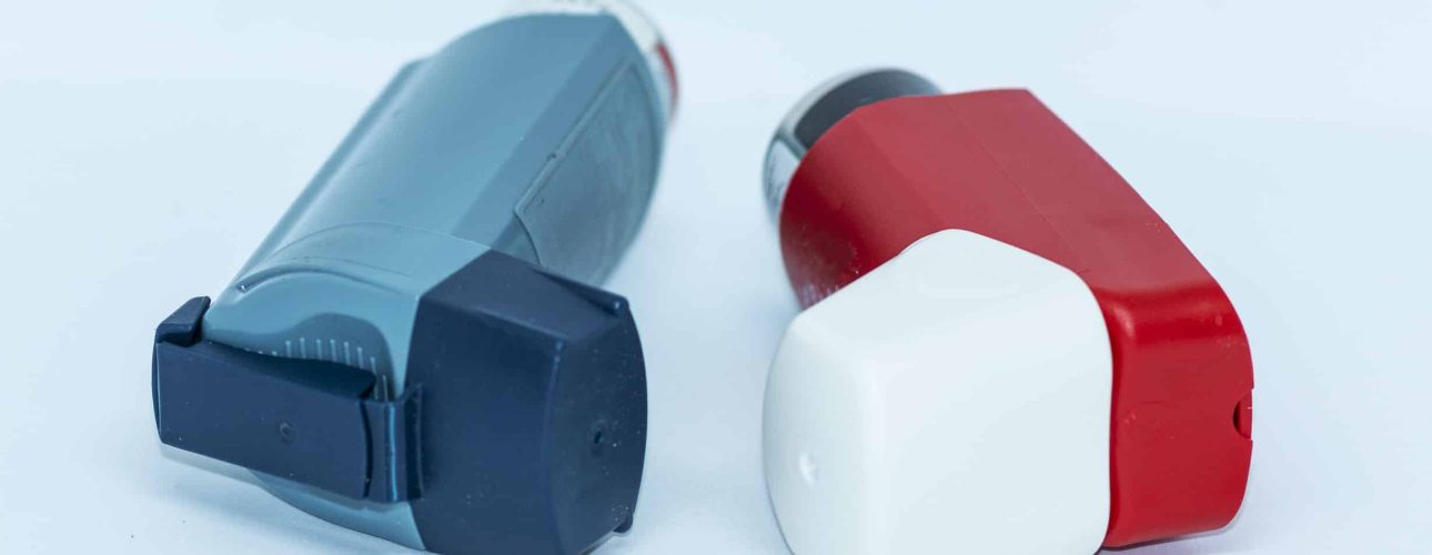 Two asthma inhalers with a white background lying next to each other.