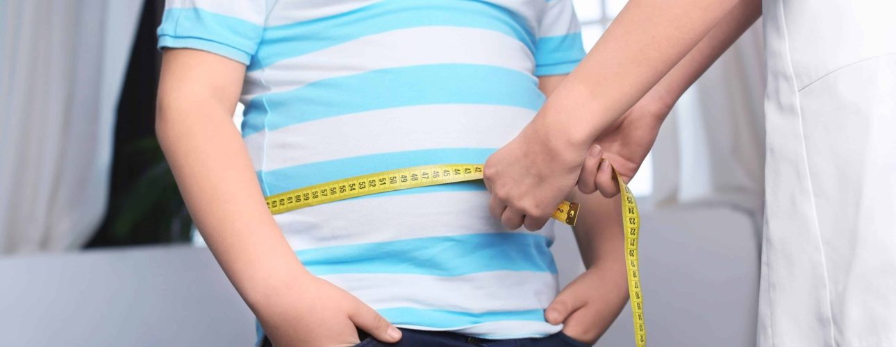 Doctor measuring overweight boy in clinic