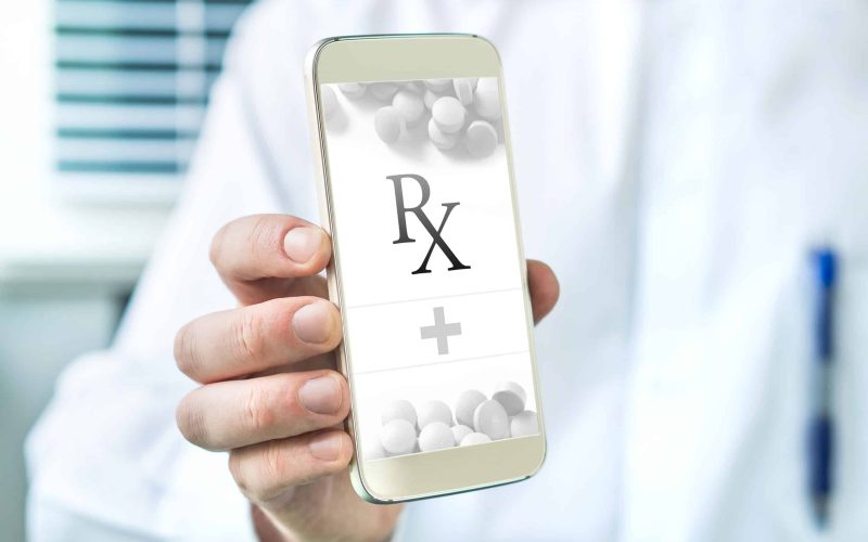 Electronic prescription. Mobile E-prescription app. Doctor giving list of medicine to patient. Pharmacist holding smartphone with an imaginary medical application.