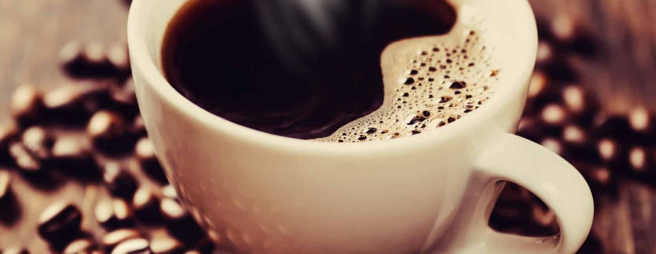 Steaming cup of freshly brewed coffee. Shallow depth of field