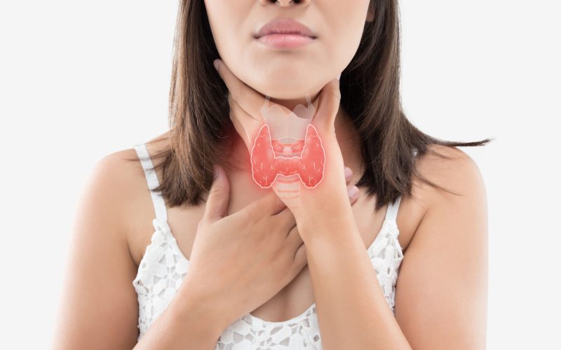 The photo of thyroid is on the human body, Women thyroid gland control. Sore throat of a people against gray background.