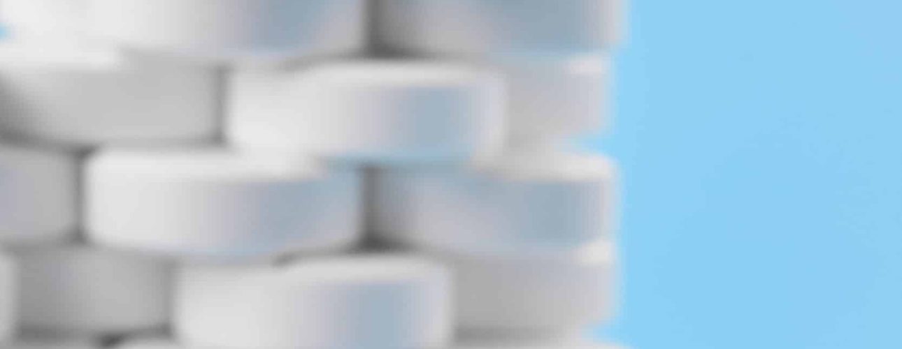 Pills tablets capsules closeup. On a blue background, a jar of medicine. White pills on the background