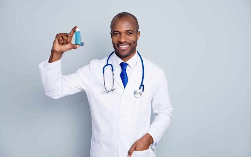 Photo of family doc dark skin guy hold inhaler asthma attack advising, medical prescription against self-treatment concept wear stethoscope lab coat isolated grey color background