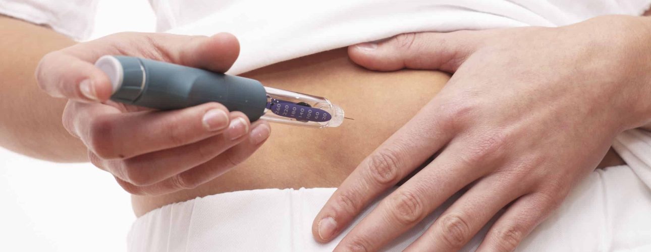 Young woman is injecting Insulin with a Insulin Pen