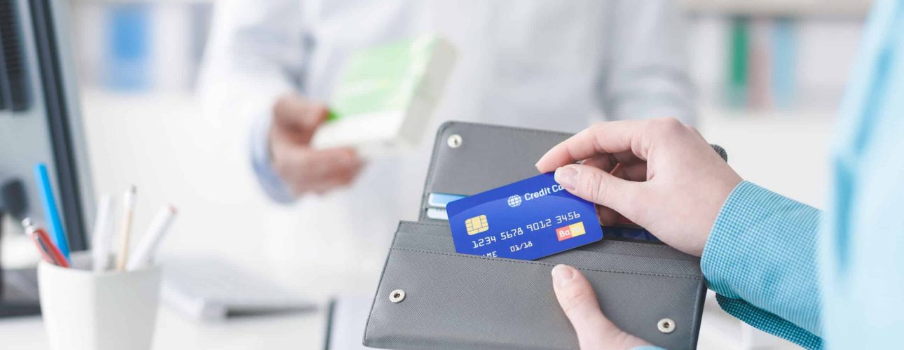 Woman buying medical products in the pharmacy, she is taking the credit card from the wallet