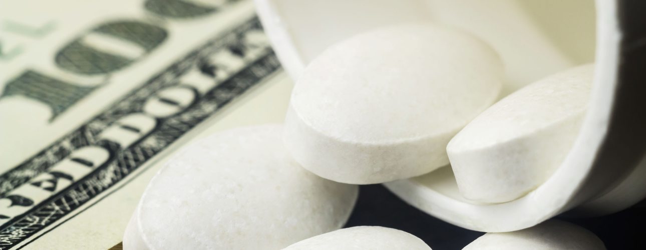 White pills of calcium, vitamin supplement, medical tablets in bottle on dollar banknote, macro image.