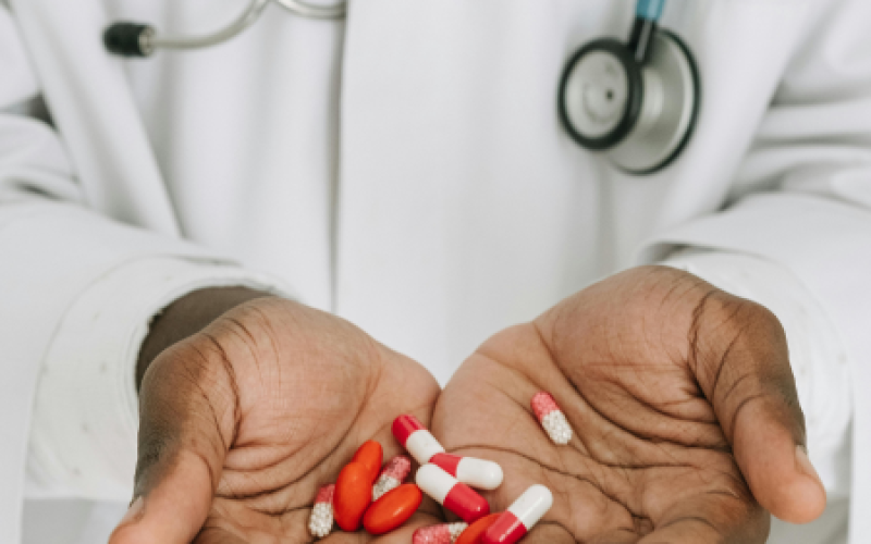 hands holding a collection of pills, representing blood thinners in an article about blood thinner tips