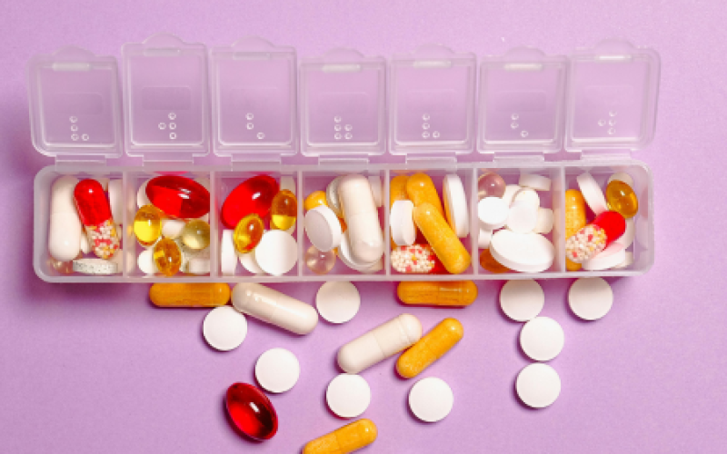 A pill organizer with pills near it, representing medication tracking tips