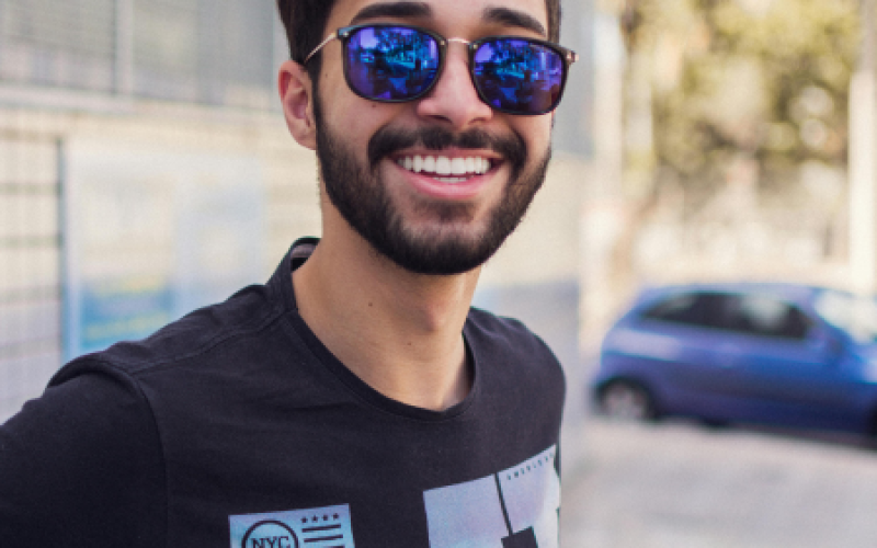 a man with sunglasses smiles, representing how some people feel after taking Abilify for mood disorders
