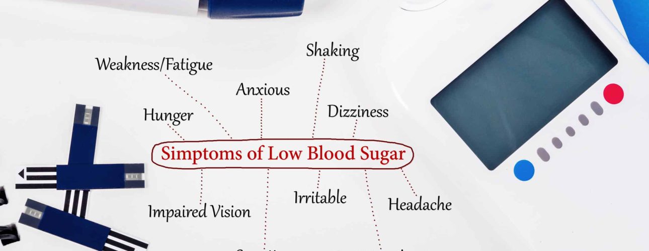 Symptoms of low blood sugar with blood glucose meter and equipment on book background.