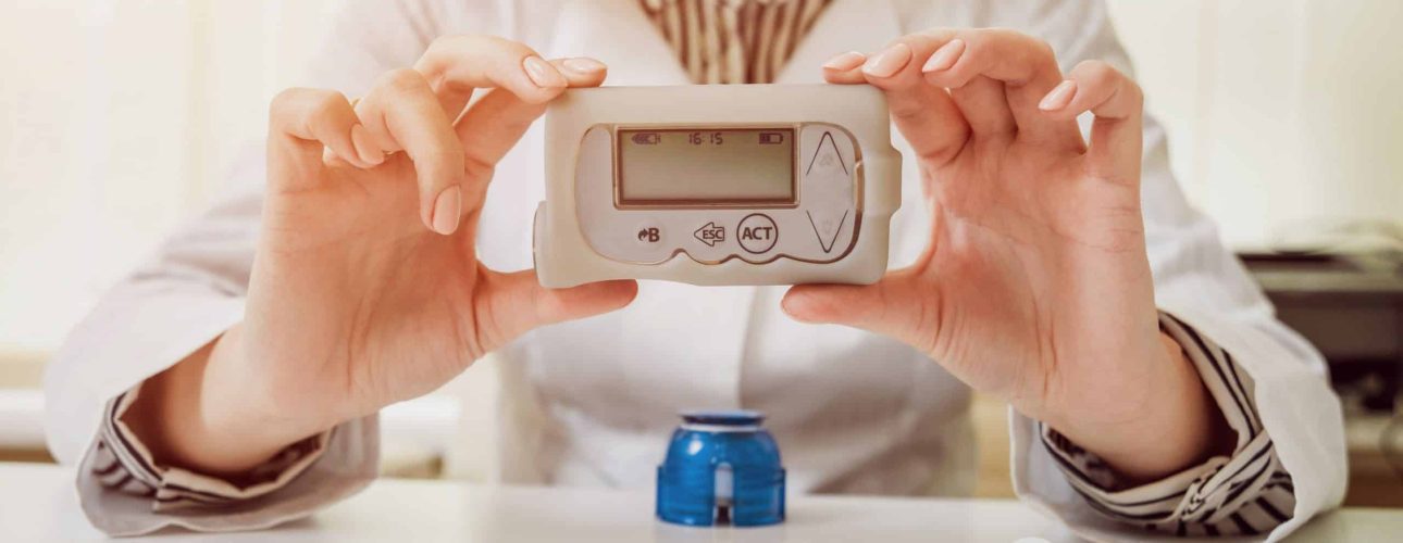 Doctor holding the insulin pump at his hands. Diabetes concept.