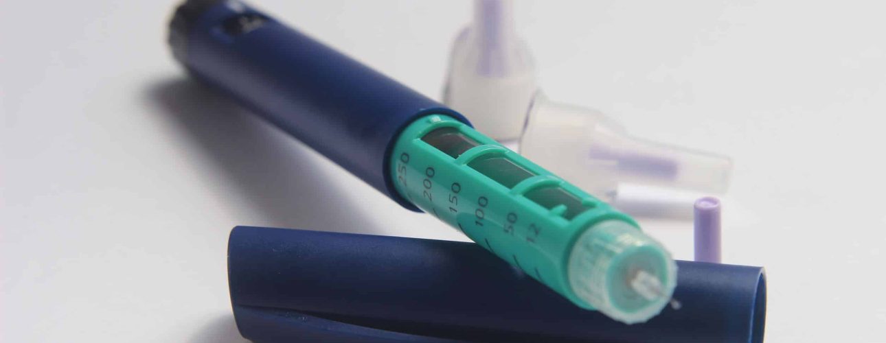 146686224 - close up photo, blue and green insulin pen at white background