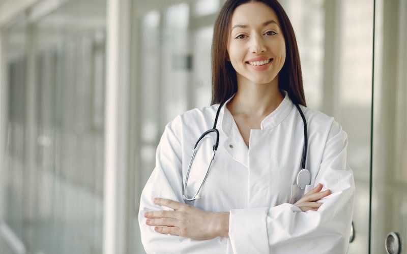 doctor standing in hospital setting smiling at patient
