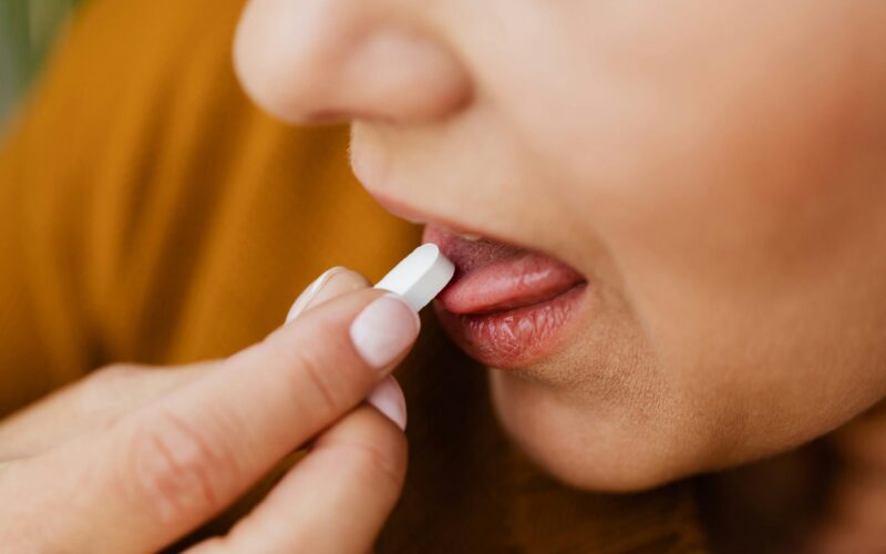 woman taking a pill, representing a person who might take Bosulif